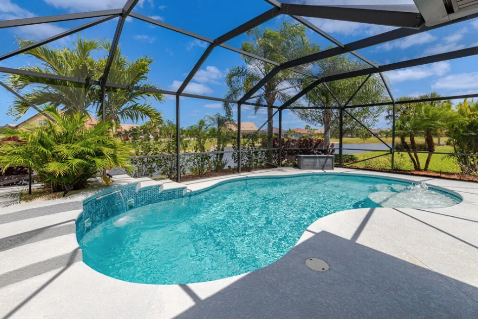 Screened saltwater pool with waterfall and bubbler at 348 SE Courances Drive — resort-style backyard pool home in Port St. Lucie FL